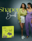 Two women standing next to a box labeled 'Shaper Brief' with a dark background